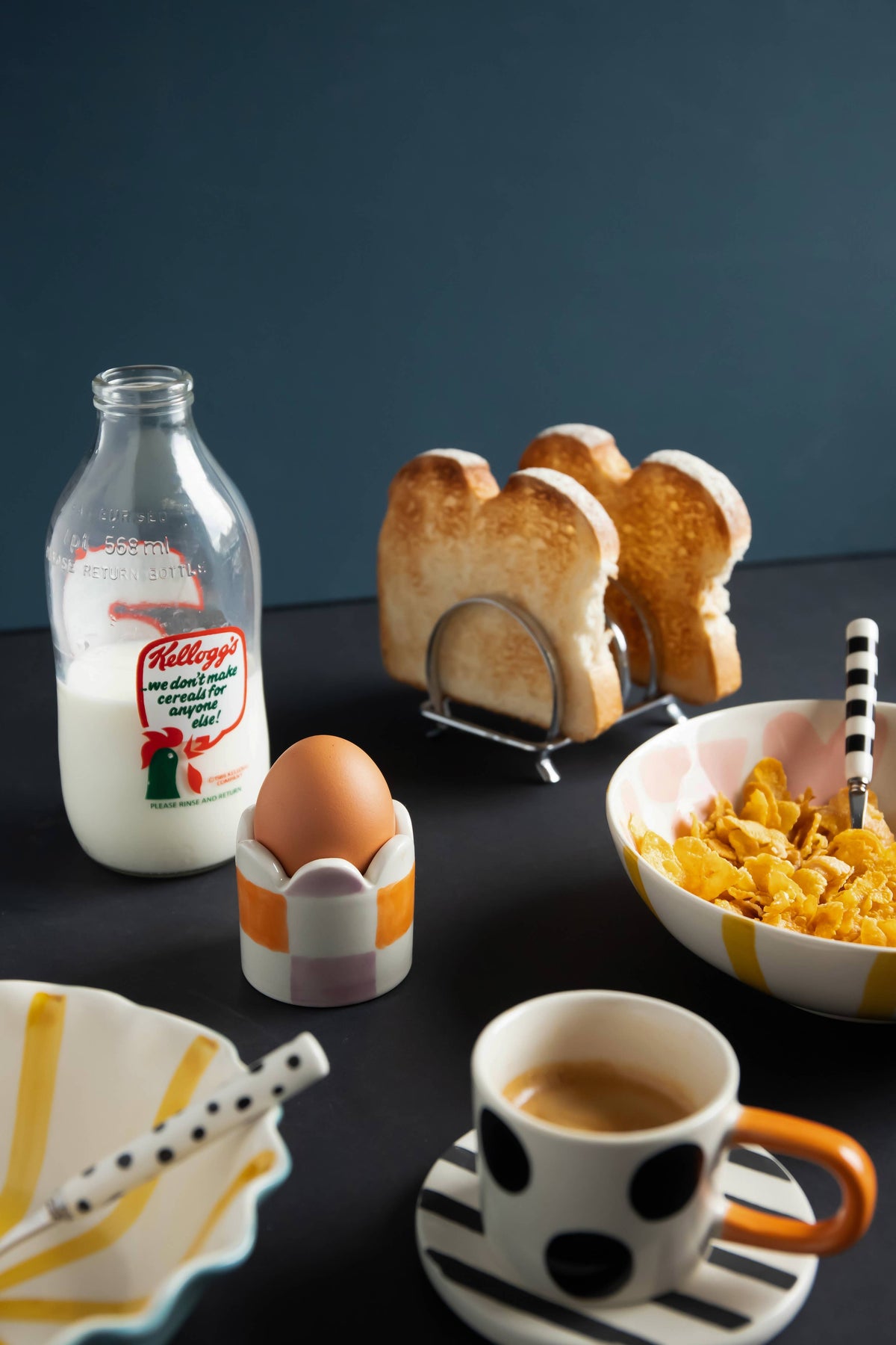 Breakfast setup with Kellogg's cereal, toast, and coffee on a dark surface.