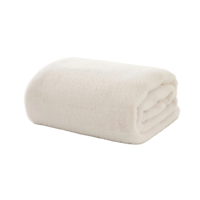 Folded ivory faux fur blanket on a white background
