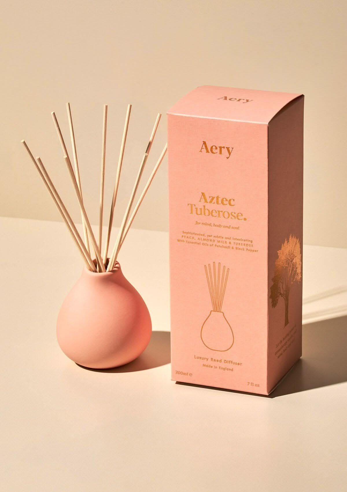 Pink diffuser with reeds and packaging labeled 'Aery' on a beige background