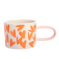 Mug with orange heart patterns on a white background
